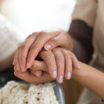 caregiver holding hands with loved one